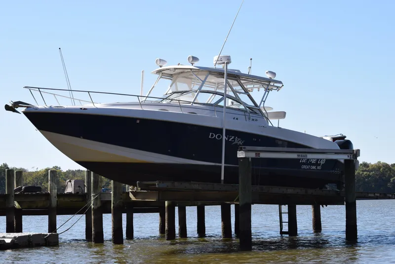Slide: The Image of 2005 Donzi 38 ZSF boat docked on a lift by the water. - 4