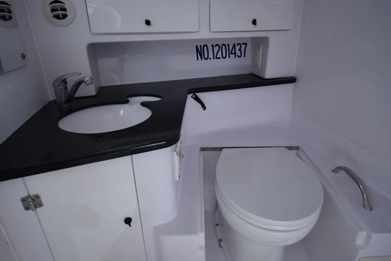 Slide: The Image of 2005 Donzi 38 ZSF boat bathroom with sink, toilet, and storage cabinets. - 43