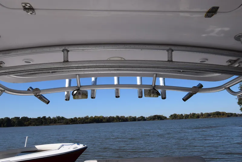 Slide: The Image of 2005 Donzi 38 ZSF boat with rod holders, overlooking a serene lake view. - 46