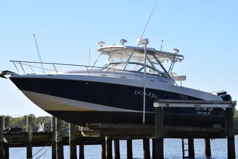 Slide: The Image of 2005 Donzi 38 ZSF boat on lift, docked by the water. - 5