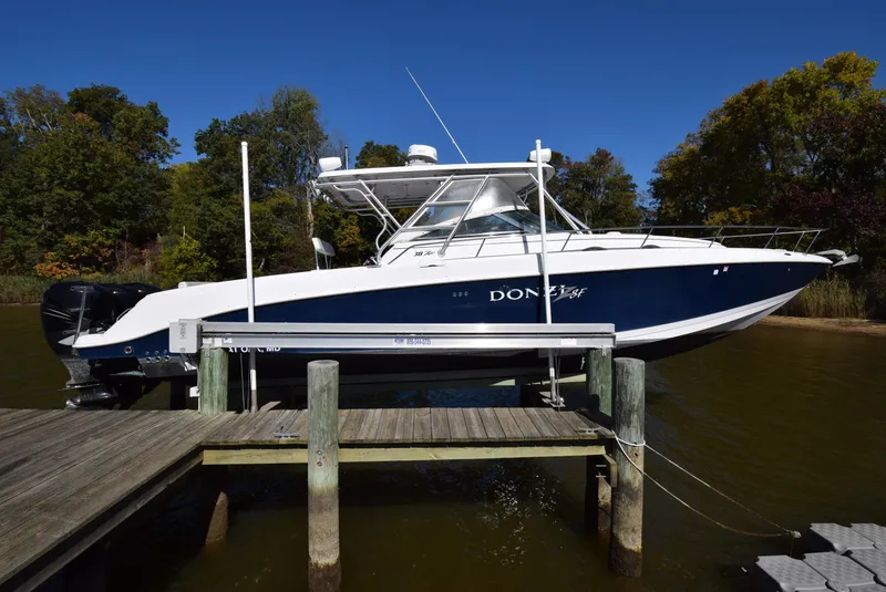 Slide: The Image of 2005 Donzi 38 ZSF boat docked, featuring sleek design and blue hull. - 6