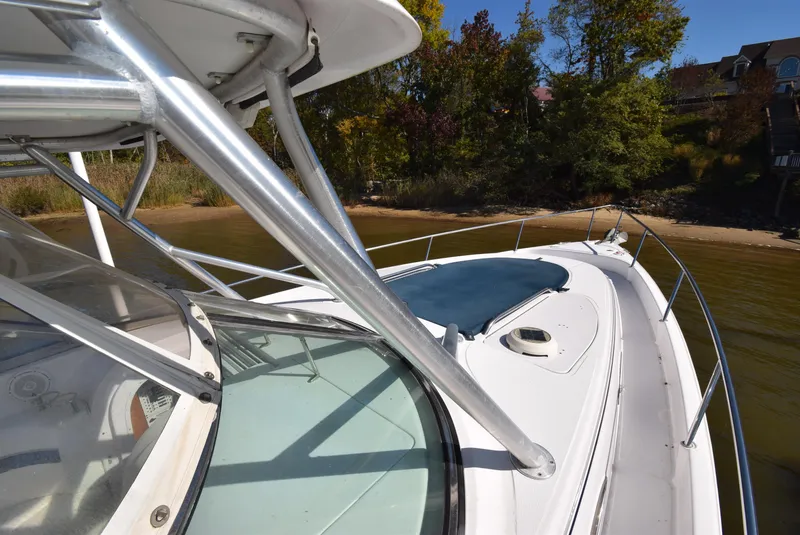 Slide: The Image of 2005 Donzi 38 ZSF boat docked near a sandy shoreline with trees. - 9
