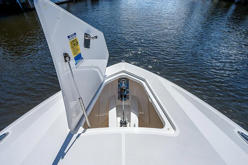Slide: The Image of 2021 Tiara Yachts 34 LS bow anchor compartment open on calm water. - 15