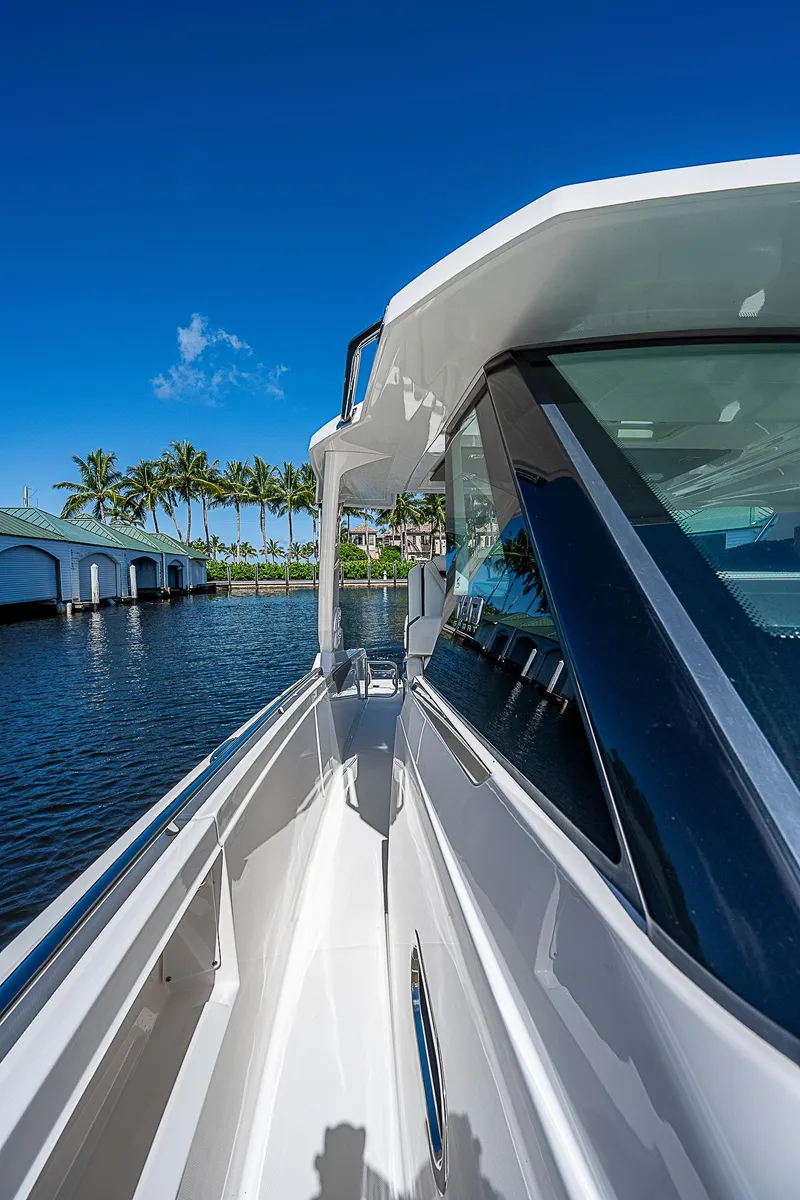 Slide: The Image of 2021 Tiara Yachts 34 LS on water, sleek design, sunny day, palm trees in background. - 18