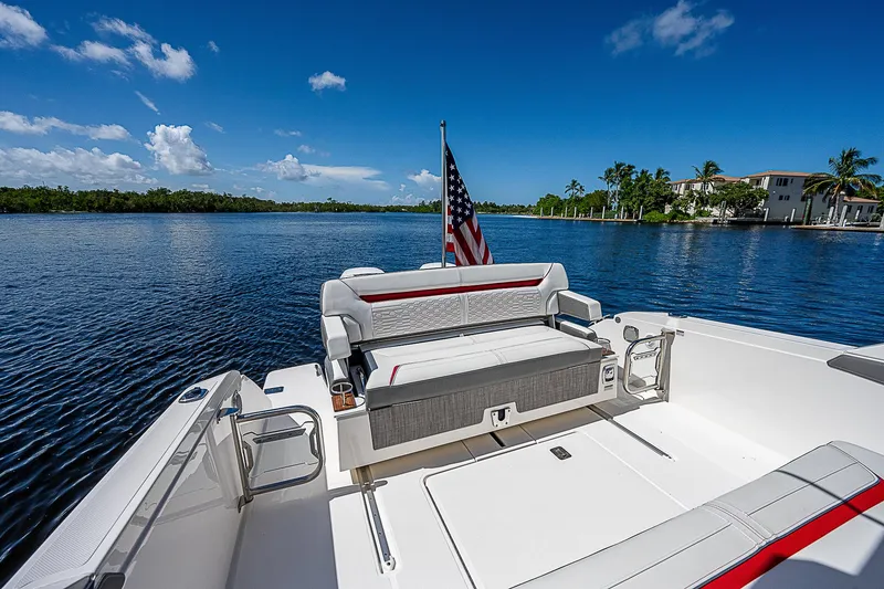 Slide: The Image of 2021 Tiara Yachts 34 LS on serene water, featuring spacious seating and American flag. - 28