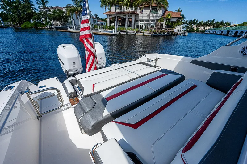 Slide: The Image of 2021 Tiara Yachts 34 LS luxury boat with American flag, docked by waterfront mansion. - 35