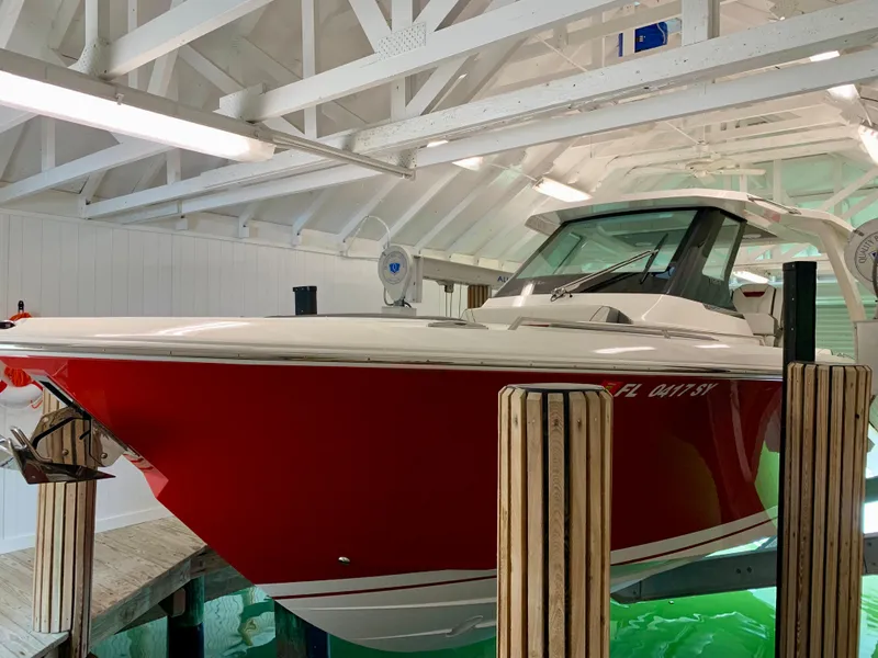 Slide: The Image of 2021 Tiara Yachts 34 LS in a boathouse, featuring a sleek red hull. - 41