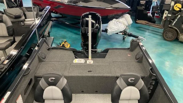 Slide: The Image of 2025 Crestliner 1650 Hawk boat interior with seating and motor, displayed in showroom. - 4