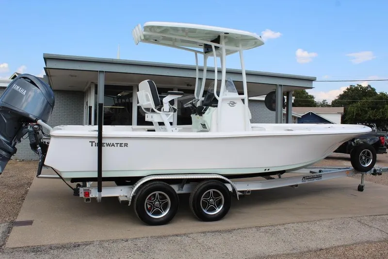 The Image of 2025 Tidewater 2210 Carolina Bay boat on trailer, featuring Yamaha engine, parked outdoors. - 0