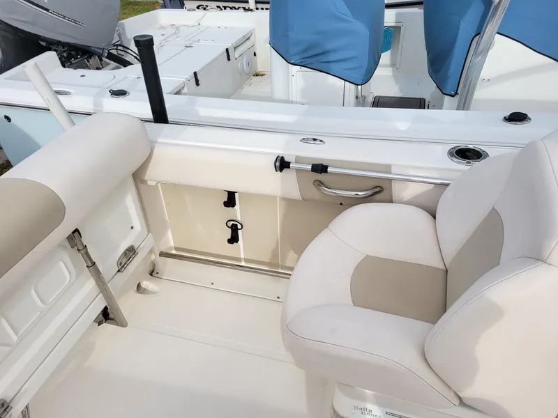 Slide: The Image of 2017 Robalo R227 Dual Console boat interior with beige seating and storage compartments. - 6