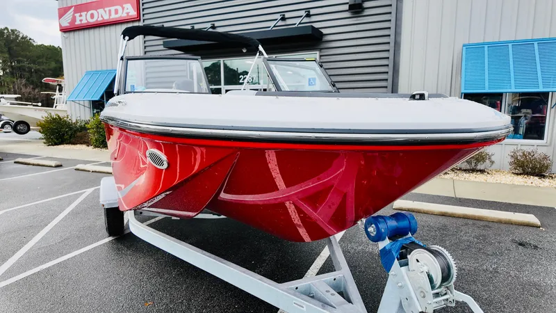 Slide: The Image of 2025 Bayliner M17 boat in vibrant red, displayed outside a Honda dealership. - 4