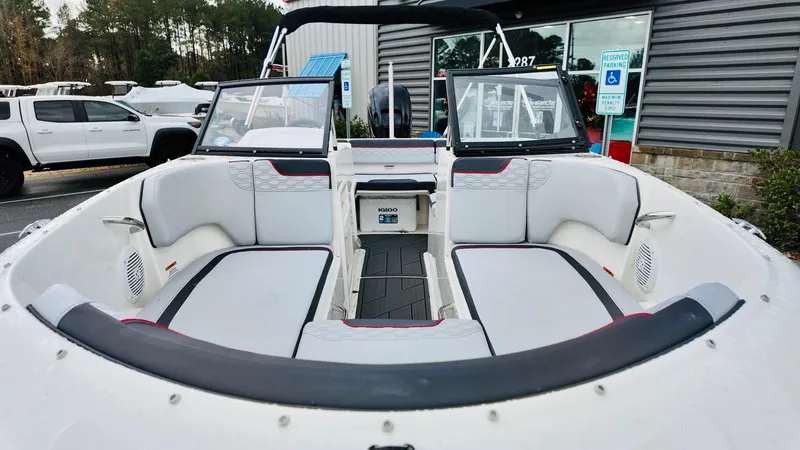 Slide: The Image of 2025 Bayliner M17 boat interior with white seating and windshield, parked outdoors. - 8