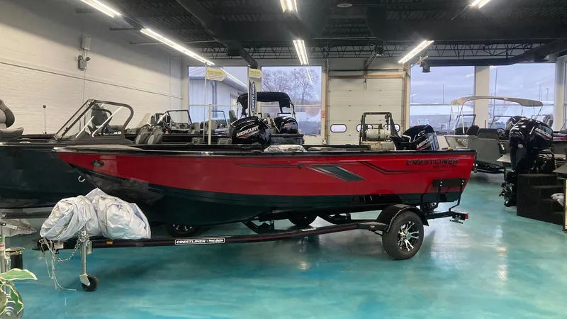 The Image of 2025 Crestliner 1650 Pro Tiller boat in showroom, red and black design. - 0