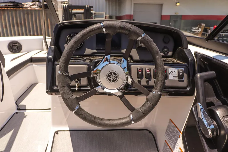 Slide: The Image of 2025 Yamaha AR195 boat steering wheel and dashboard controls. - 10