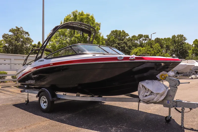 Slide: The Image of 2025 Yamaha Boats AR195 on trailer, black and red design, parked outdoors. - 6