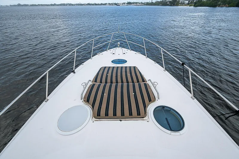 Slide: The Image of 2008 Regal Commodore 3760 IB boat deck with striped sun pad on calm water. - 24