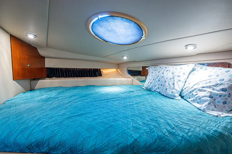 Slide: The Image of Cozy cabin interior of 2008 Regal Commodore 3760 IB with blue bedding and ambient lighting. - 33