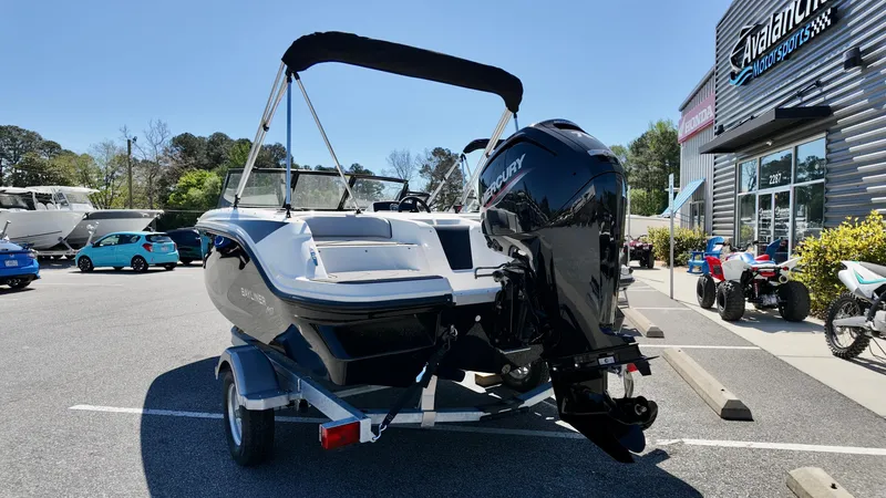 Slide: The Image of 2025 Bayliner M17 boat with Mercury engine, parked outside dealership on a sunny day. - 1