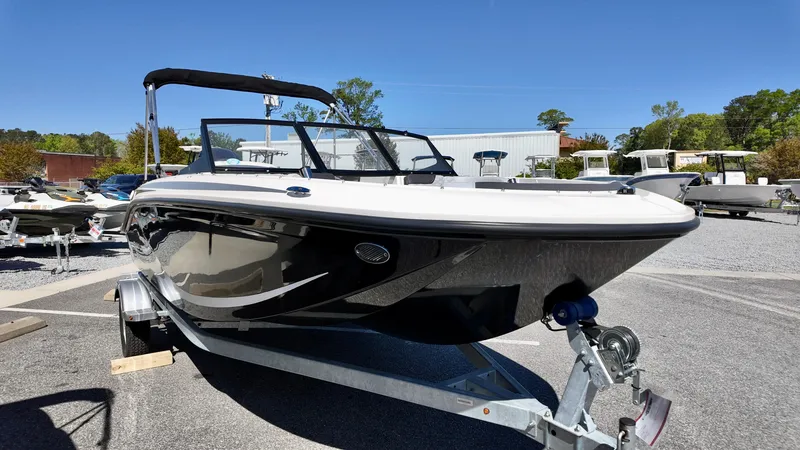 Slide: The Image of 2025 Bayliner M17 boat on trailer, sleek design, parked outdoors under clear blue sky. - 3
