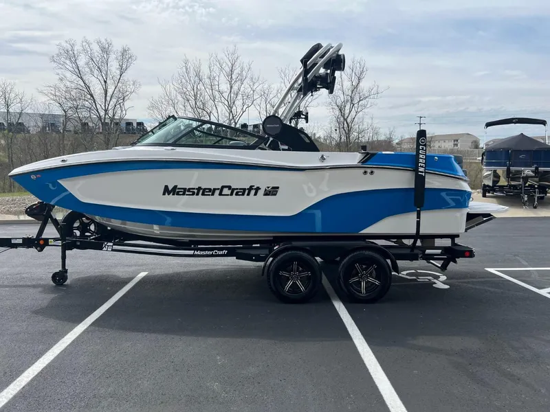 Slide: The Image of 2024 MasterCraft XT20 boat on trailer in parking lot. - 6