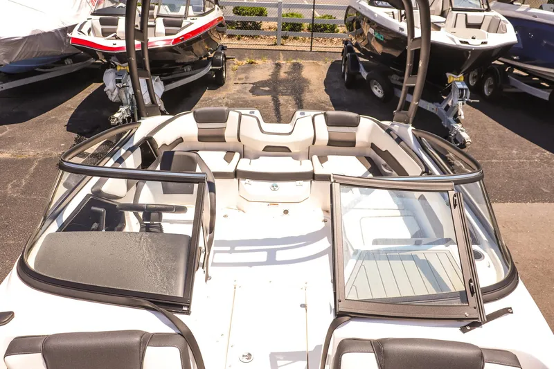 Slide: The Image of 2025 Yamaha Boats AR195, sleek design, open bow seating, parked in marina. - 14