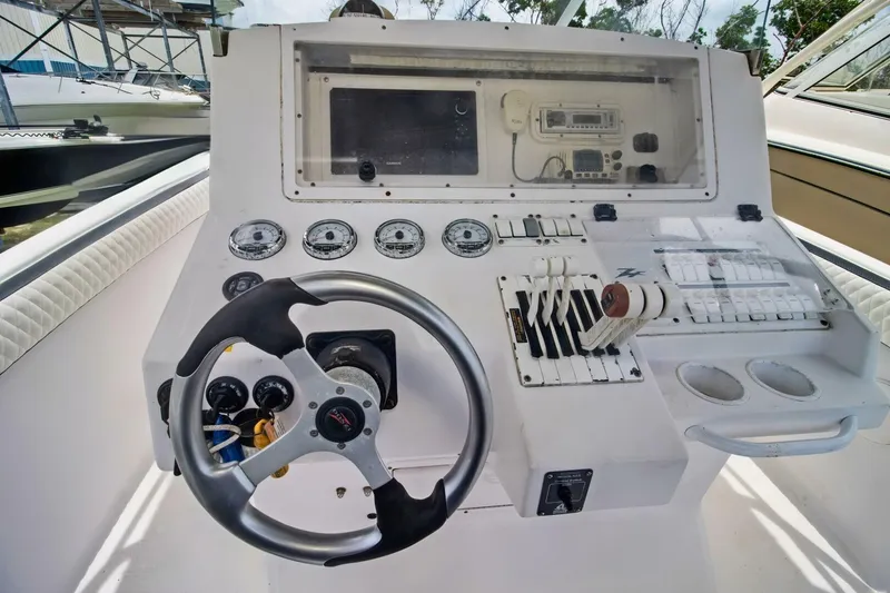Slide: The Image of 2005 Donzi 35 ZF Cuddy boat dashboard with steering wheel and control panel. - 12