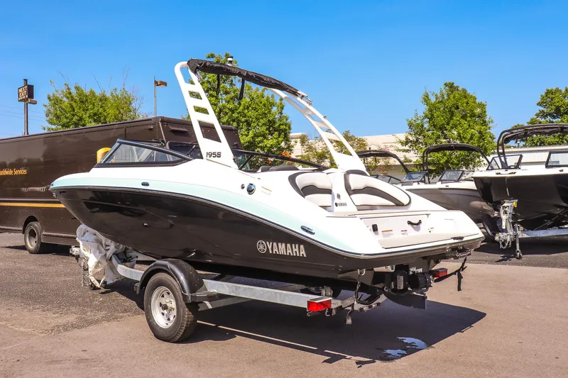 Slide: The Image of 2025 Yamaha Boats 195S on trailer, sleek design, parked outdoors under clear blue sky. - 3