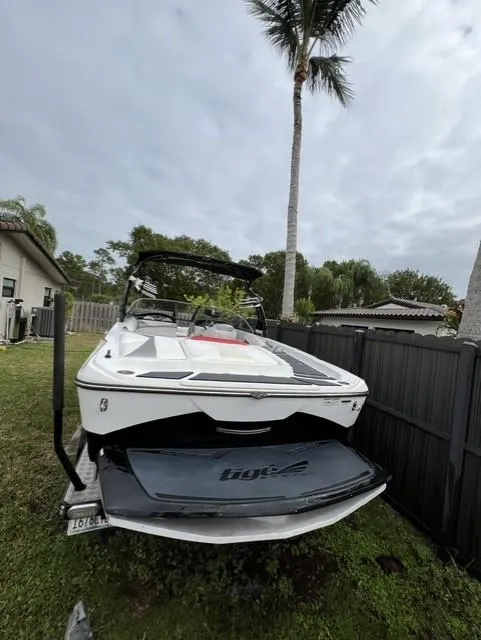 Slide: The Image of 2015 Tigé RZR boat parked in a backyard with palm trees. - 13