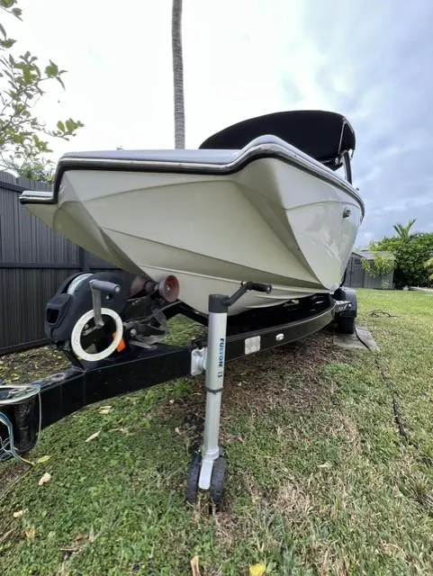 Slide: The Image of 2015 Tigé RZR boat on trailer, parked on grass. - 2