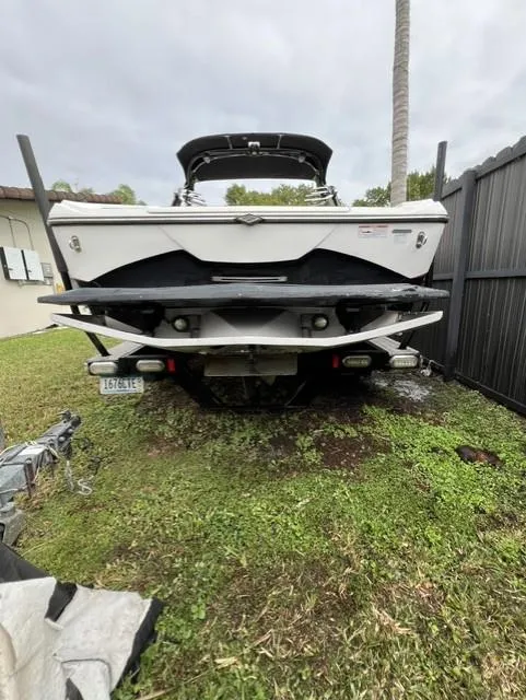 Slide: The Image of 2015 Tigé RZR boat parked on grass near a fence. - 8