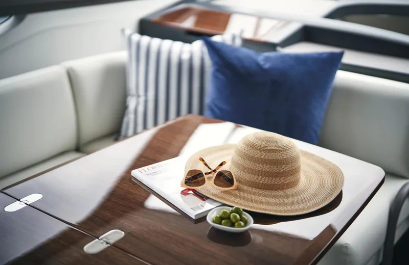 Slide: The Image of Luxurious interior of 2025 Princess F50 yacht with hat, sunglasses, and grapes on table. - 21