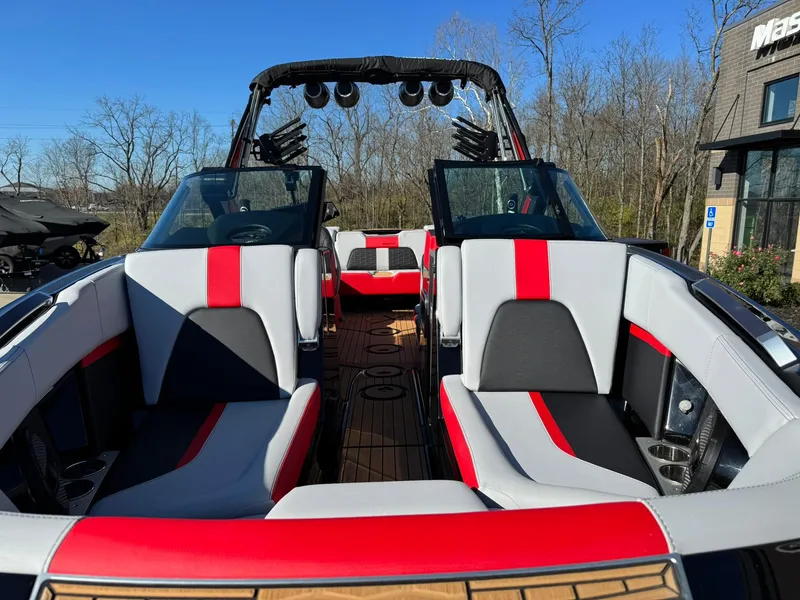 Slide: The Image of 2024 MasterCraft X24 boat interior with red and gray seating, outdoor setting. - 6