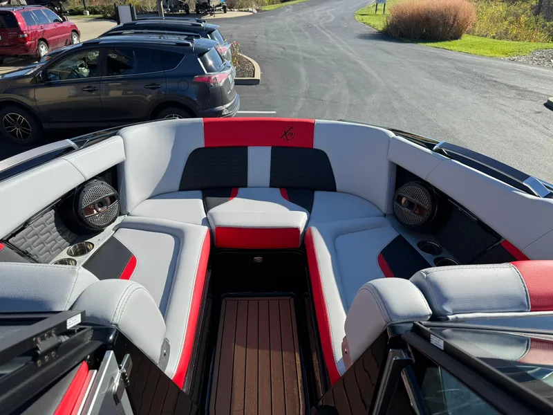 Slide: The Image of 2024 MasterCraft X24 boat interior with red and gray seating, premium audio system. - 7
