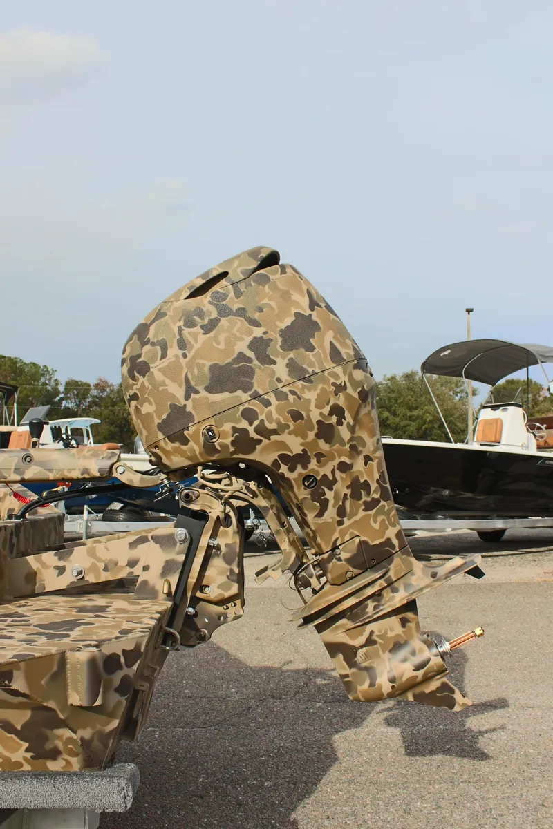 Slide: The Image of 2025 Excel 1860 Viper F4 CC boat with camouflage motor, parked outdoors. - 11