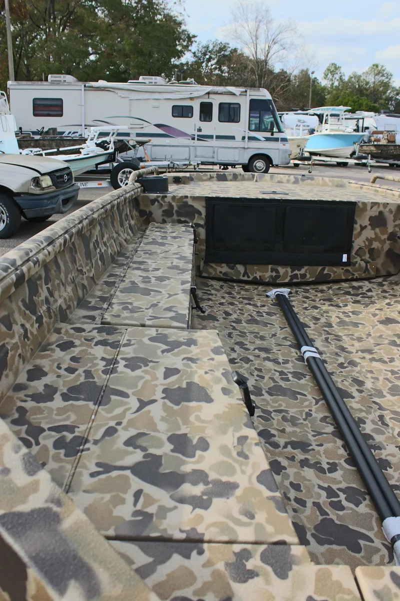 Slide: The Image of 2025 Excel 1860 Viper F4 CC boat with camouflage interior, parked near RVs and vehicles. - 12