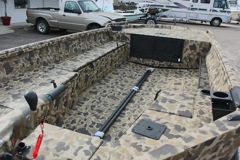 Slide: The Image of 2025 Excel 1860 Viper F4 CC boat with camouflage interior, parked near vehicles. - 14