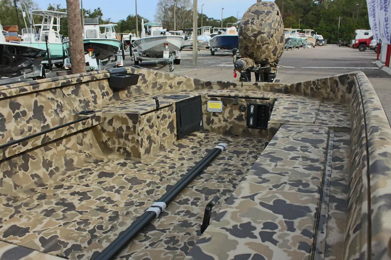 Slide: The Image of 2025 Excel 1860 Viper F4 CC boat with camouflage design in a marina setting. - 16