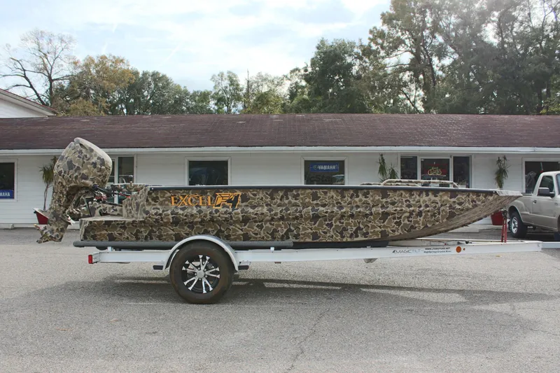 Slide: The Image of 2025 Excel 1860 Viper F4 CC boat on trailer, camo design, parked outdoors. - 7