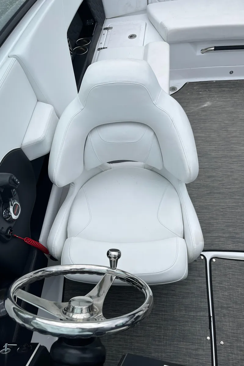 Slide: The Image of 2022 Four Winns H4 OB boat interior with white captain's chair and steering wheel. - 16