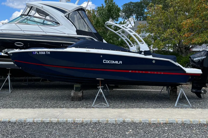 Slide: The Image of 2022 Four Winns H4 OB boat on stands, blue hull, outdoor display. - 2