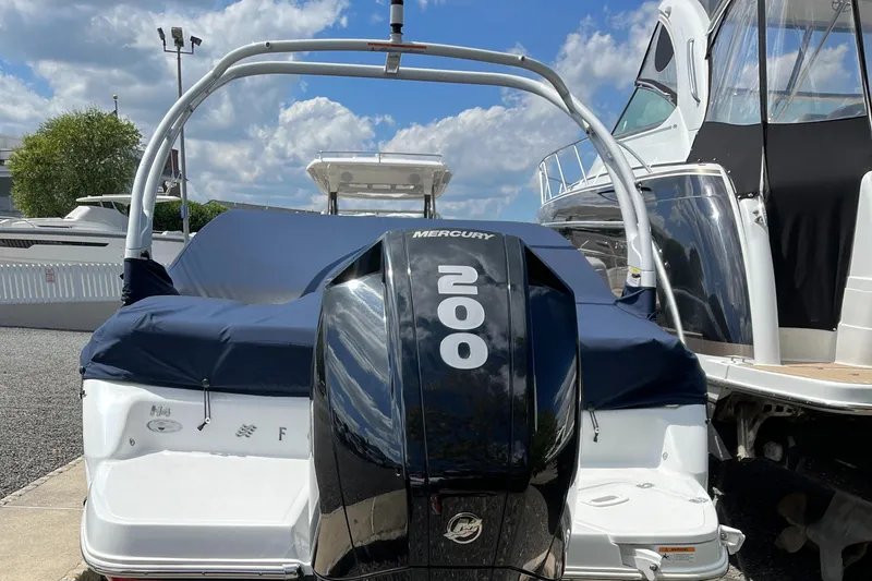 Slide: The Image of 2022 Four Winns H4 OB boat with Mercury 200 outboard motor, docked under a blue sky. - 4