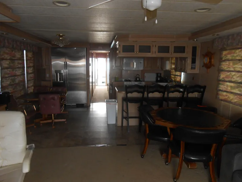 Slide: The Image of Interior of a 1999 Horizon houseboat with kitchen and dining area. - 11