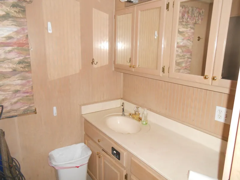 Slide: The Image of 1999 Horizon houseboat bathroom with beige cabinets and sink. - 20