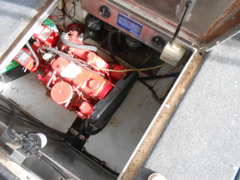 Slide: The Image of Engine compartment of a 1999 Horizon houseboat, featuring a red engine and wiring. - 40