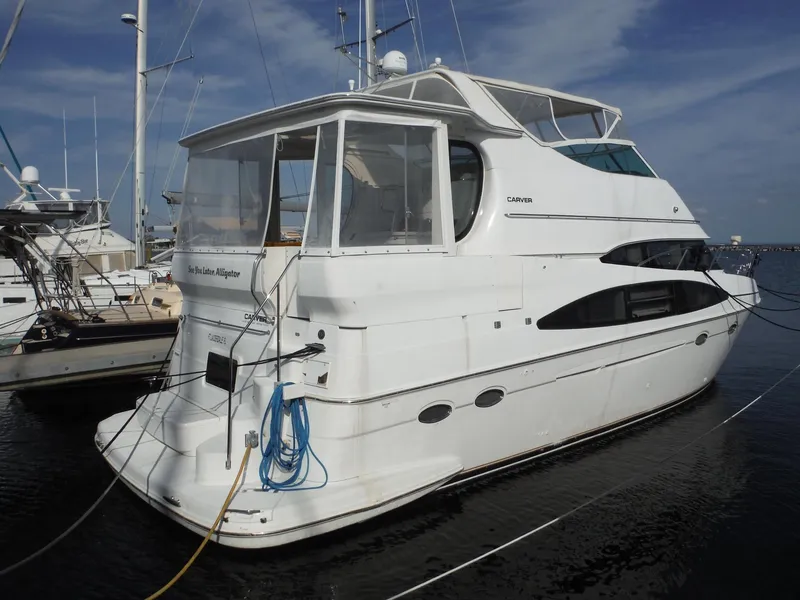 Slide: The Image of 2001 Carver 466 Motor Yacht docked in marina, white exterior, clear skies. - 0
