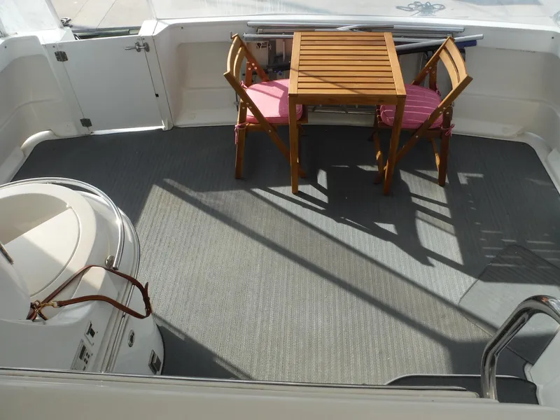 Slide: The Image of 2001 Carver 466 Motor Yacht deck with wooden table and chairs. - 12