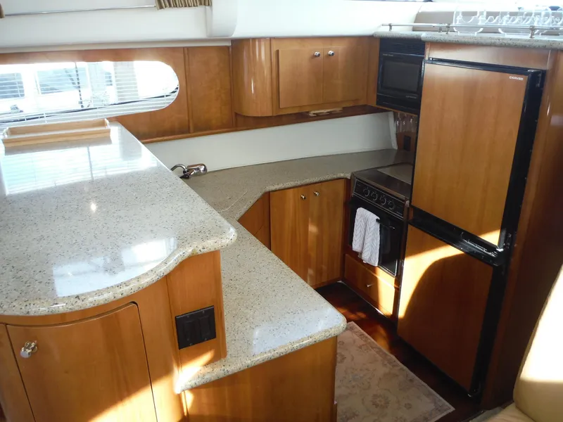 Slide: The Image of Interior of 2001 Carver 466 Motor Yacht kitchen with wood cabinetry and modern appliances. - 17