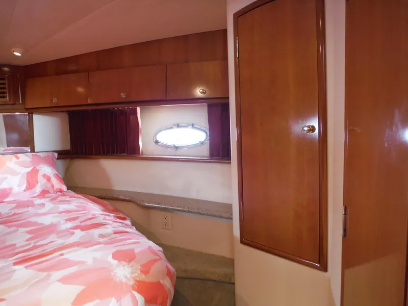 Slide: The Image of Interior cabin of 2001 Carver 466 Motor Yacht with wood paneling and floral bedding. - 34