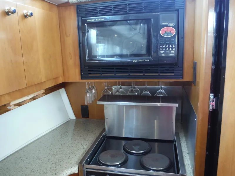 Slide: The Image of 2001 Carver 466 Motor Yacht kitchen with microwave, stove, and glass rack. - 41