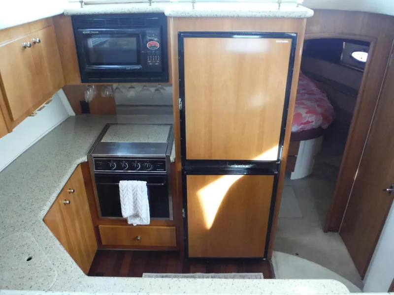 Slide: The Image of 2001 Carver 466 Motor Yacht kitchen with microwave, stove, and fridge. - 42